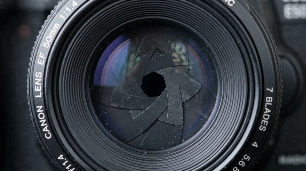 Macro view of overlapping aperture blades inside a camera lens controlling light.