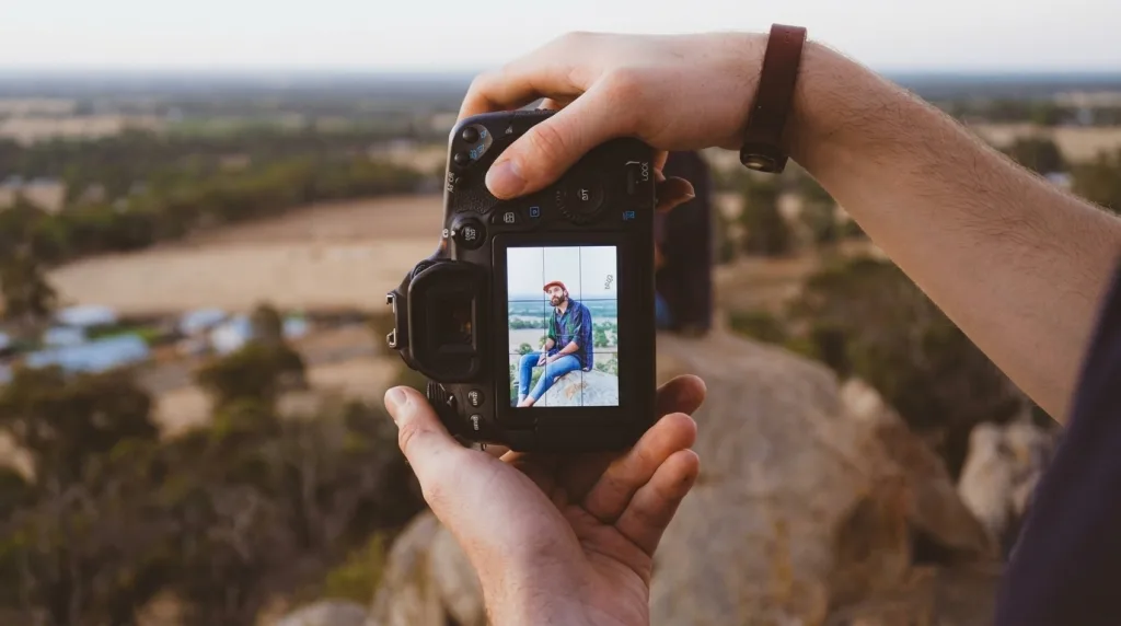 Photographer looking through the electronic viewfinder of a mirrorless camera.