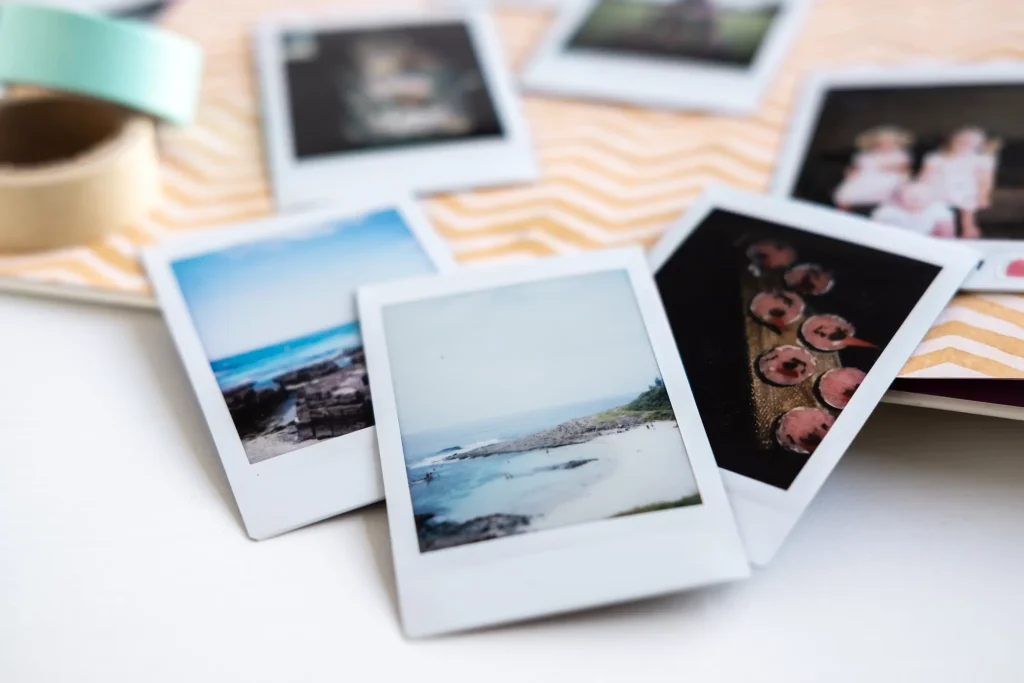 Instant film photos spread out on a wooden surface