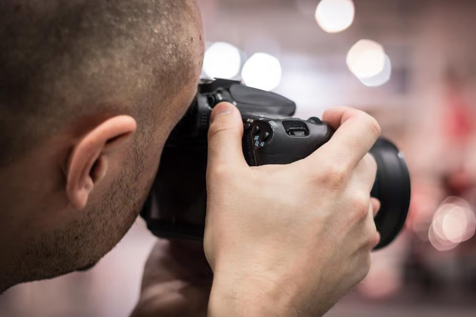 Photographer composing a shot through a DSLR camera viewfinder