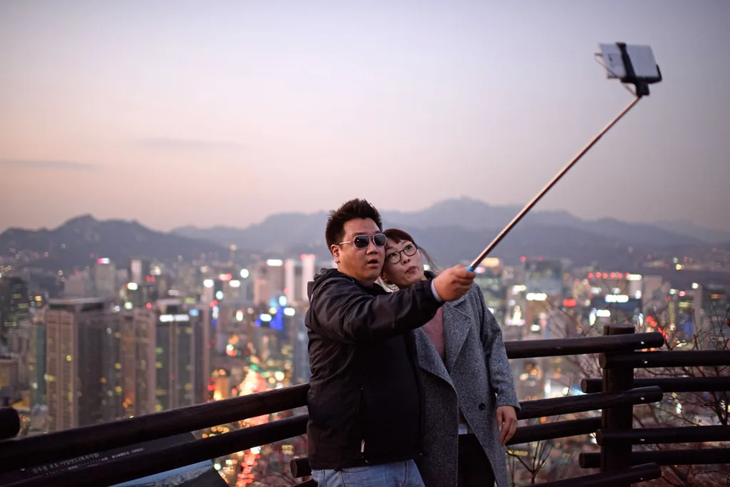 Person using a selfie stick to extend camera distance