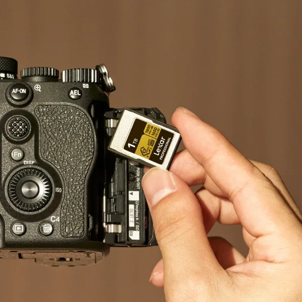 SDXC memory card being inserted into a mirrorless camera prepared for 4K recording