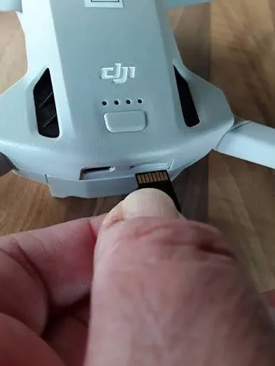 microSD card being inserted into a drone card slot for aerial photography